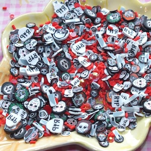 May include: A yellow, ice cream cone-shaped dish filled with red sprinkles and various Halloween-themed polymer clay pieces. The pieces include images of Jason Voorhees, Ghostface, and other horror movie characters. Some pieces have the text "RIP".