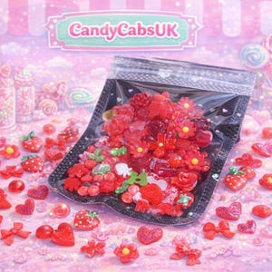 Könnte beinhalten: Eine transparente Tüte gefüllt mit roten und rosa Süßigkeiten, darunter Herzen, Blumen und Erdbeeren. Im Hintergrund Gläser mit Süßigkeiten und der Text "CandyCabsUK".