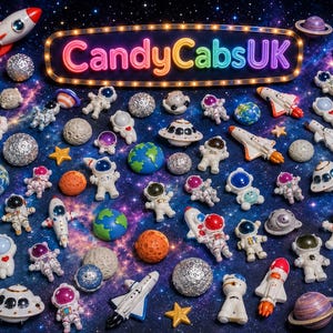 May include: A collection of space-themed figurines including astronauts, rockets, planets, and UFOs scattered across a dark blue starry background. A central illuminated sign displays the text CandyCabsUK in a colorful, glowing neon font.