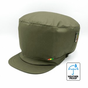Può includere: Un berretto in stile militare verde oliva con visiera piatta e corona alta e arrotondata. Una piccola etichetta sul lato riporta la scritta Hatafaya con una striscia rossa, gialla e verde. Una piccola linguetta rossa, gialla e verde è sulla visiera.