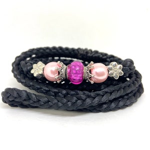 May include: A black braided cord leash with pink and purple beads and silver crown charms.