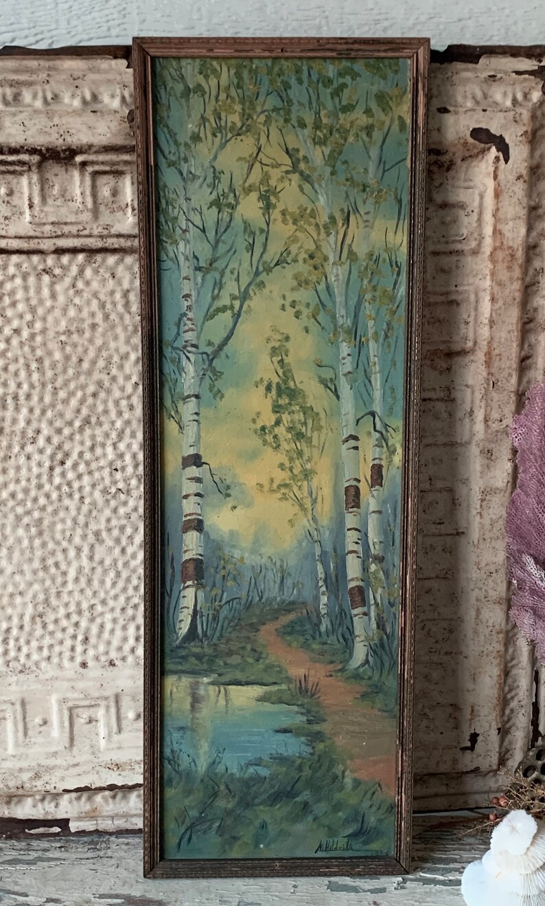 Peut inclure: Une peinture encadr&eacute;e repr&eacute;sentant une sc&egrave;ne de for&ecirc;t avec des bouleaux, un chemin et un petit &eacute;tang. La peinture est r&eacute;alis&eacute;e dans un style r&eacute;aliste avec des couleurs douces. La signature de l'artiste est visible en bas &agrave; droite.