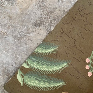 May include: A vintage wallpaper with a brown background and a repeating pattern of green wheat stalks and pink flowers.