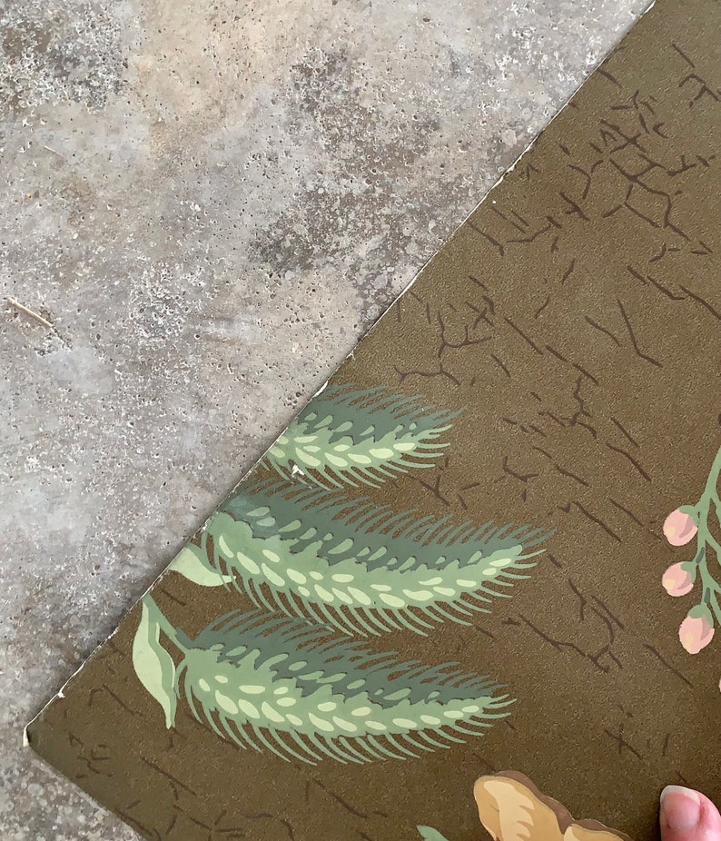 May include: A vintage wallpaper with a brown background and a repeating pattern of green wheat stalks and pink flowers.