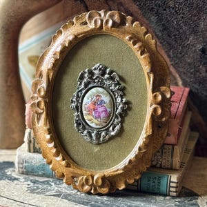 Vintage ornate plastic framed porcelain medallion courting couple metal cherubs plaque wall picture