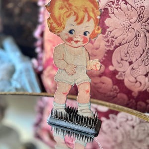 May include: A white ceramic mug with a black handle and the text "But First, Coffee" in a black, handwritten-style font. The mug is on a white surface.