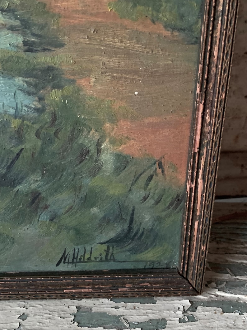 Peut inclure: Une peinture encadr&eacute;e repr&eacute;sentant une sc&egrave;ne de paysage avec des arbres verts et un fond brun. La peinture est sign&eacute;e "M. Hilditch" et dat&eacute;e de "1933".