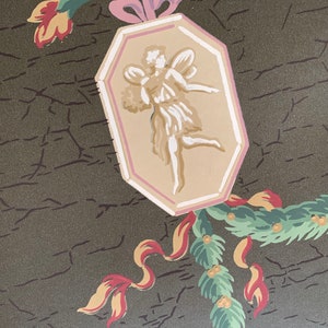May include: A vintage wallpaper design featuring a green, pink, and yellow floral motif with a central octagonal panel depicting a white fairy with wings. The background is a dark green with a cracked texture.