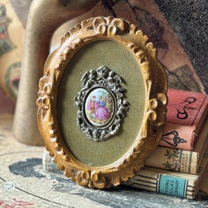 Vintage ornate plastic framed porcelain medallion courting couple metal cherubs plaque wall picture