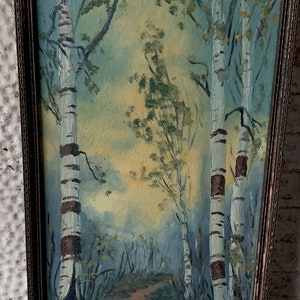 Peut inclure: Une peinture encadr&eacute;e repr&eacute;sentant une sc&egrave;ne de for&ecirc;t avec trois bouleaux au premier plan. Les arbres sont peints dans des tons de blanc et de brun, avec un ciel bleu clair en arri&egrave;re-plan. La peinture est encadr&eacute;e dans un cadre en bois.