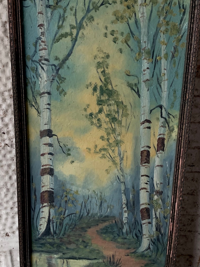 Peut inclure: Une peinture encadr&eacute;e repr&eacute;sentant une sc&egrave;ne de for&ecirc;t avec trois bouleaux au premier plan. Les arbres sont peints dans des tons de blanc et de brun, avec un ciel bleu clair en arri&egrave;re-plan. La peinture est encadr&eacute;e dans un cadre en bois.