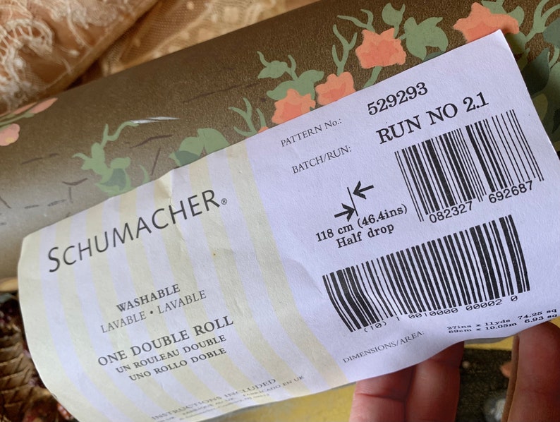 May include: A white label with black text and a barcode. The label reads "SCHUMACHER. PATTERN No.: 529293 BATCH/RUN: RUN NO 2.1 WASHABLE LAVABLE LAVABLE ONE DOUBLE ROLL UN ROULEAU DOUBLE UNO ROLLO DOBLE 118 cm (46.4ins) Half drop 082327 692687 DIMENSIONS/AREA".