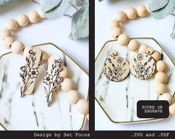 Puede incluir: Dos pares de pendientes de madera con un diseño floral. Los pendientes están en un plato blanco con cuentas de madera. También se puede ver el texto "SCORE OR ENGRAVE" y ".SVG and .PDF".