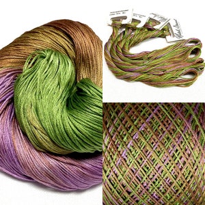 May include: A skein of hand-dyed stranded cotton embroidery floss in shades of brown, green, and purple. The floss is wound into a ball and has a gradient effect. The skein is labelled "Hand Dyed Stranded Cotton 12" and "Madelinetosh".