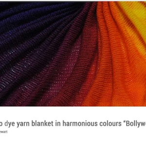 May include: A knitted blanket in a gradient of colours, transitioning from deep purple to red, orange, and finally, yellow. The fabric has a textured appearance, with visible yarn strands. The title "How to dye yarn blanket in harmonious colours "Bollywood"" is displayed below.