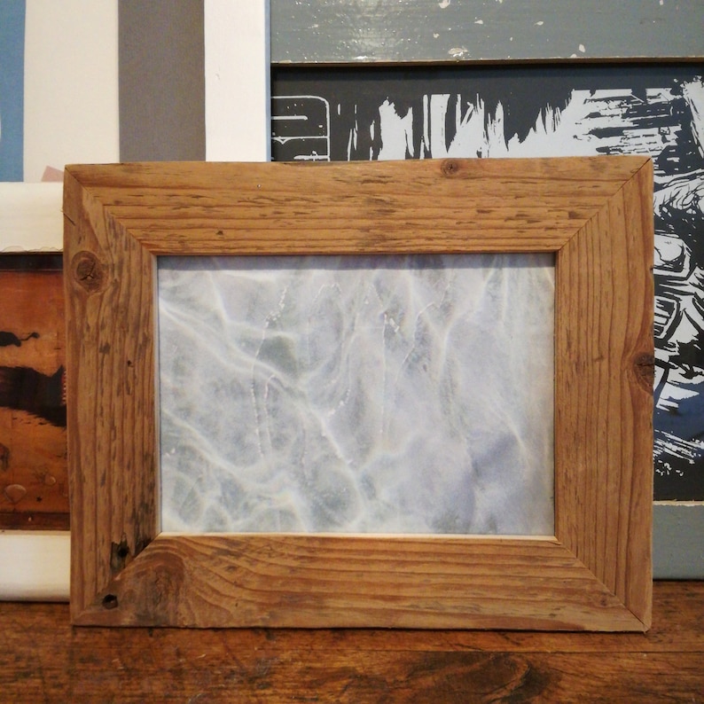 May include: A rustic wooden picture frame with a light blue and white abstract print inside. The frame is made of reclaimed wood and has a natural finish.