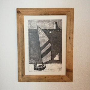 Könnte beinhalten: Ein gerahmter Schwarzweißdruck eines Segelboots mit gestreiften Segeln auf dem Wasser. Der Druck ist in einem Holzrahmen.