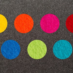 May include: Seven felt circles in different colors on a gray background. The colors are yellow, orange, pink, red, blue, green, and turquoise.