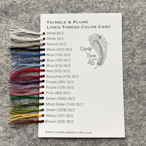 Puede incluir: Una carta de colores que muestra una variedad de colores de hilo de lino, incluyendo blanco, natural, negro, azul, rojo, burdeos, morado, rosa, verde, verde musgo, amarillo y marrón. La tarjeta está etiquetada como "Thimble & Plume Linen Thread Color Card" e incluye la dirección del sitio web "www.thimbleandplume.com".