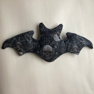 Skulls and paisley bat-shaped pillow