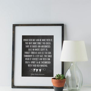 May include: A black framed print with a white background and a quote by Ralph Waldo Emerson. The quote reads: "Finish each day and be done with it. You have done what you could. Some blunders and absurdities have no doubt crept in. Forget them as soon as you can. Tomorrow is a new day. You shall begin it serenely and with too high a spirit to be encumbered with your old nonsense."