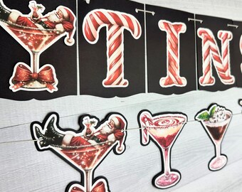 May include: A black and red Christmas banner with the word "TINSEL" in white letters. The banner is decorated with candy cane designs and features Santa Claus in a martini glass.