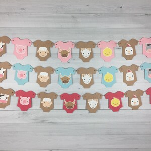 May include: A banner with farm animal baby onesies in pink, blue, brown, and red. The onesies have different animal faces on them, including a cow, pig, sheep, bull, chick, rooster, and horse.