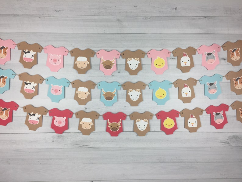 May include: A banner with farm animal baby onesies in pink, blue, brown, and red. The onesies have different animal faces on them, including a cow, pig, sheep, bull, chick, rooster, and horse.