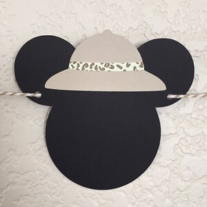 Puede incluir: Orejas de Mickey Mouse negras y blancas con un sombrero safari de color canela con una banda de estampado de leopardo marr&oacute;n y blanco. El sombrero est&aacute; colocado encima de las orejas.