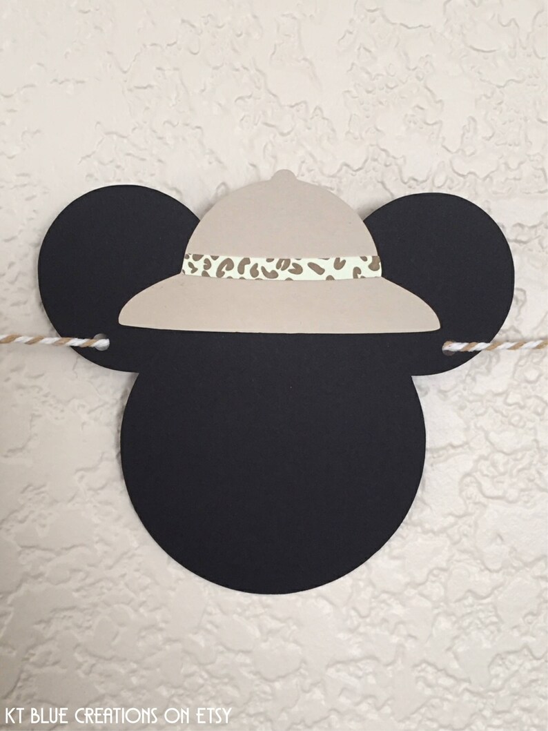 Puede incluir: Orejas de Mickey Mouse negras y blancas con un sombrero safari de color canela con una banda de estampado de leopardo marr&oacute;n y blanco. El sombrero est&aacute; colocado encima de las orejas.