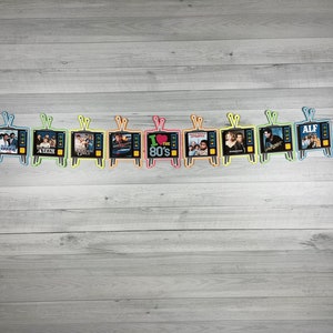 May include: A string of 12 colorful television-shaped decorations with images of popular 1980s television shows, including "The Facts of Life", "ALF", "I Love the 80s", and "Punky Brewster".