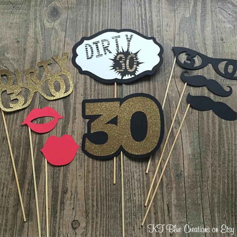 May include: A set of 7 photo booth props for a 30th birthday party. The props include a pair of glasses that say "Dirty 30", a sign that says "Dirty 30", a large number "30" with gold glitter, a pair of red lips, a mustache, and a pair of glasses with the number "30" on them.