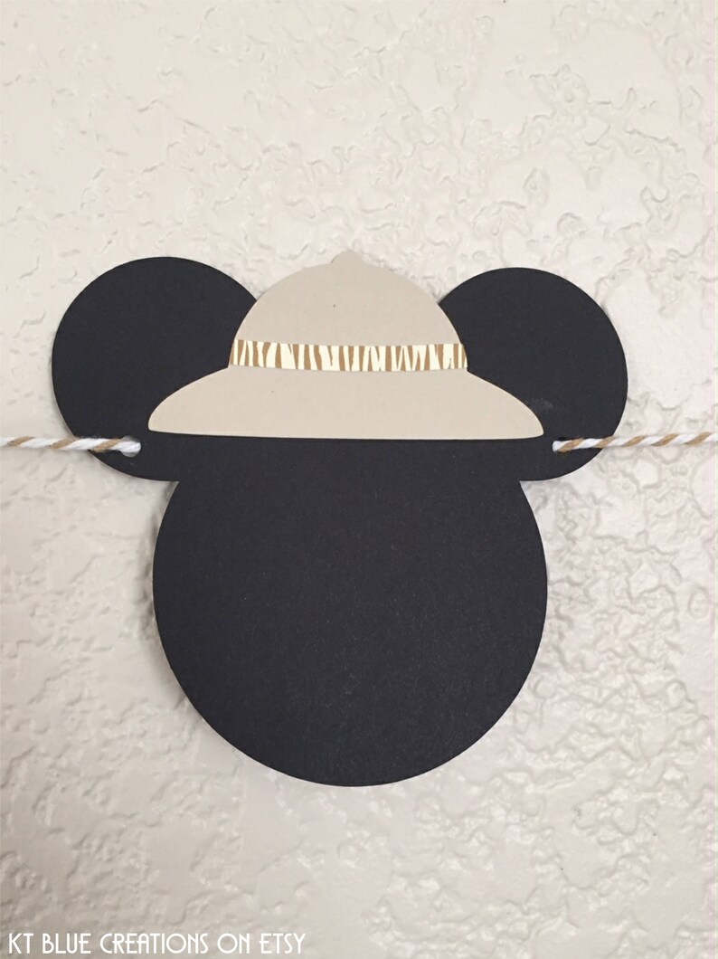 Puede incluir: Orejas de Mickey Mouse negras y blancas con un sombrero safari de color marr&oacute;n claro en la parte superior. El sombrero tiene una banda de rayas marrones y blancas.