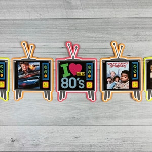 May include: A colorful banner with a retro television theme. The banner features images from popular 1980s television shows, including "Knight Rider", "I Love the 80's", and "Different Strokes".