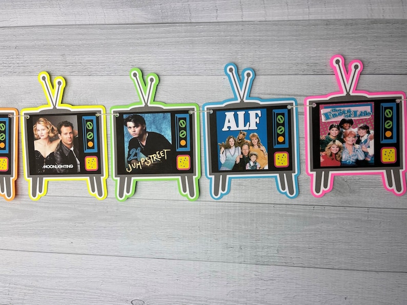 May include: A banner with five television-shaped cutouts, each featuring a different 80s television show. The shows are "Moonlighting", "21 Jump Street", "ALF", "The Facts of Life", and "The Golden Girls".