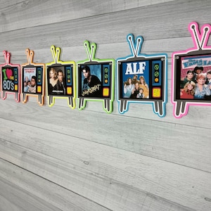 May include: A colorful banner with 8 retro TV-shaped cutouts featuring images from popular 1980s shows, including "ALF", "The Facts of Life", "Jump Street", "Different Strokes", and "I Love the 80's".
