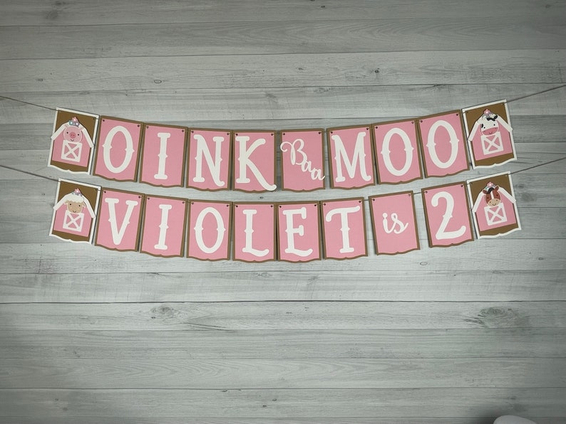 May include: Pink and brown banner with the text "OINK Moo Violet is 2" with farm animal illustrations.