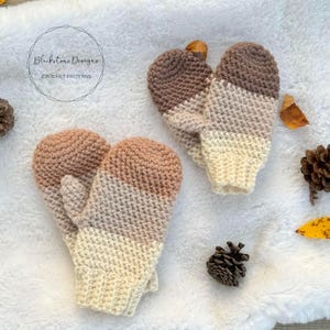 May include: A pair of crocheted mittens in a beige, brown, and cream color scheme. The mittens are made with a textured stitch and have a simple, classic design. Blackstone Designs Crochet Patterns is printed on the white background.