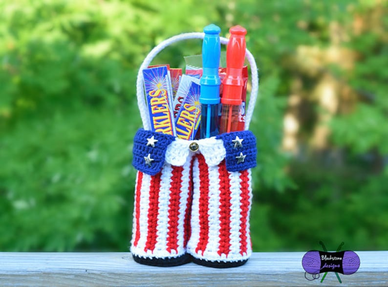 Pu&ograve; includere: Un cestino patriottico all'uncinetto in rosso, bianco e blu, pieno di scintille e bacchette per bolle. Il cestino ha un manico ed &egrave; decorato con stelle e strisce, perfetto per una festa patriottica.