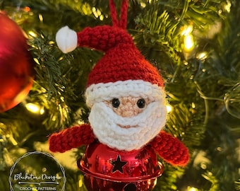 May include: A crocheted Santa Claus ornament with a white beard and red hat, holding a red jingle bell with a star cutout. The ornament is hanging on a Christmas tree.