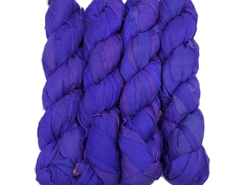 Può includere: Quattro fasci di nastro di seta sari viola vibrante, strettamente attorcigliati e disposti su sfondo bianco. La seta presenta un colore ricco e saturo con sottili variazioni di tono, creando un aspetto strutturato. Ideale per lavori di artigianato e progetti tessili.
