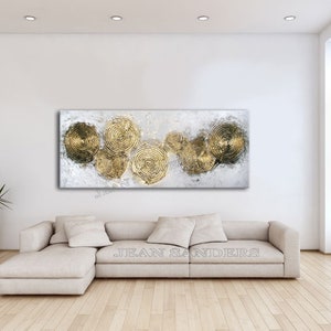May include: Abstract painting with a white background and gold circles. The circles are layered and overlapping, creating a sense of depth and movement. The painting is framed and ready to hang.