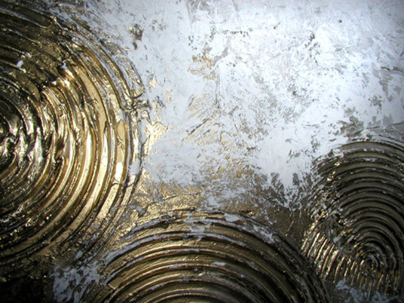 May include: Abstract painting with a textured, white background and gold concentric circles. The circles are raised and have a metallic sheen.