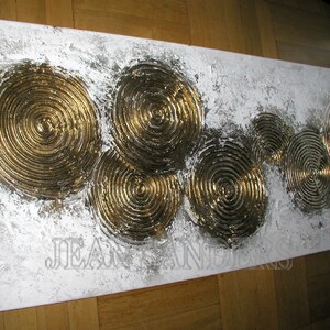 May include: Abstract painting on canvas with a white background and gold concentric circles. The circles are raised and textured, creating a 3D effect.