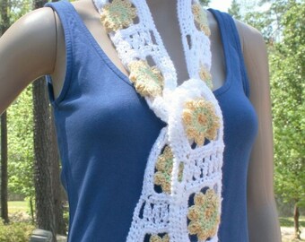 Bring some summer to your winter with crocheted spring flowers.  White scarf with yellow flowers with green accents