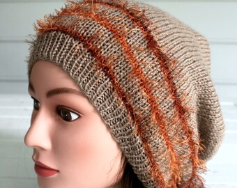 Hand knitted slouchy hat with fun eyelash trim.   Made with a light brown yarn with eyelash trim that runs orange to brown.