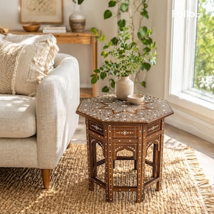 May include: An octagonal wooden side table featuring intricate white inlaid patterns across the top and sides. The table has a dark brown finish with arched cutouts on each leg and a geometric star design centered on the tabletop surface.