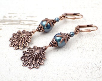 May include: Copper-coloured drop earrings with a seashell and starfish design. Each earring features a detailed seashell charm, a teal bead, and a starfish accent. The earrings have a lever-back closure.