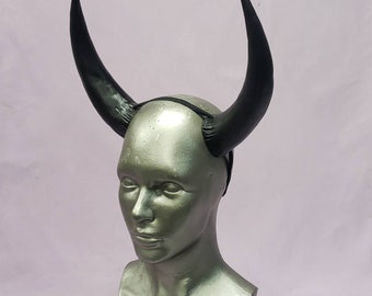 May include: Black devil horns headband costume accessory. The headband is made of black elastic and the horns are made of black plastic.