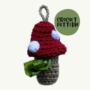 May include: Crochet pattern for a red and white mushroom-shaped dog poop bag dispenser. The dispenser has a brown crocheted base and a loop for hanging.